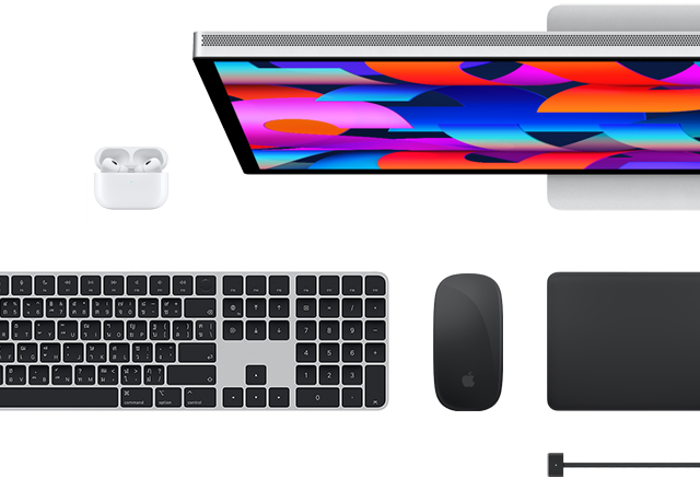มุมมองด้านบนของอุปกรณ์เสริม Mac หลายชิ้น ได้แก่ Studio Display, Magic Keyboard, Magic Mouse, Magic Trackpad, AirPods และสายชาร์จ MagSafe